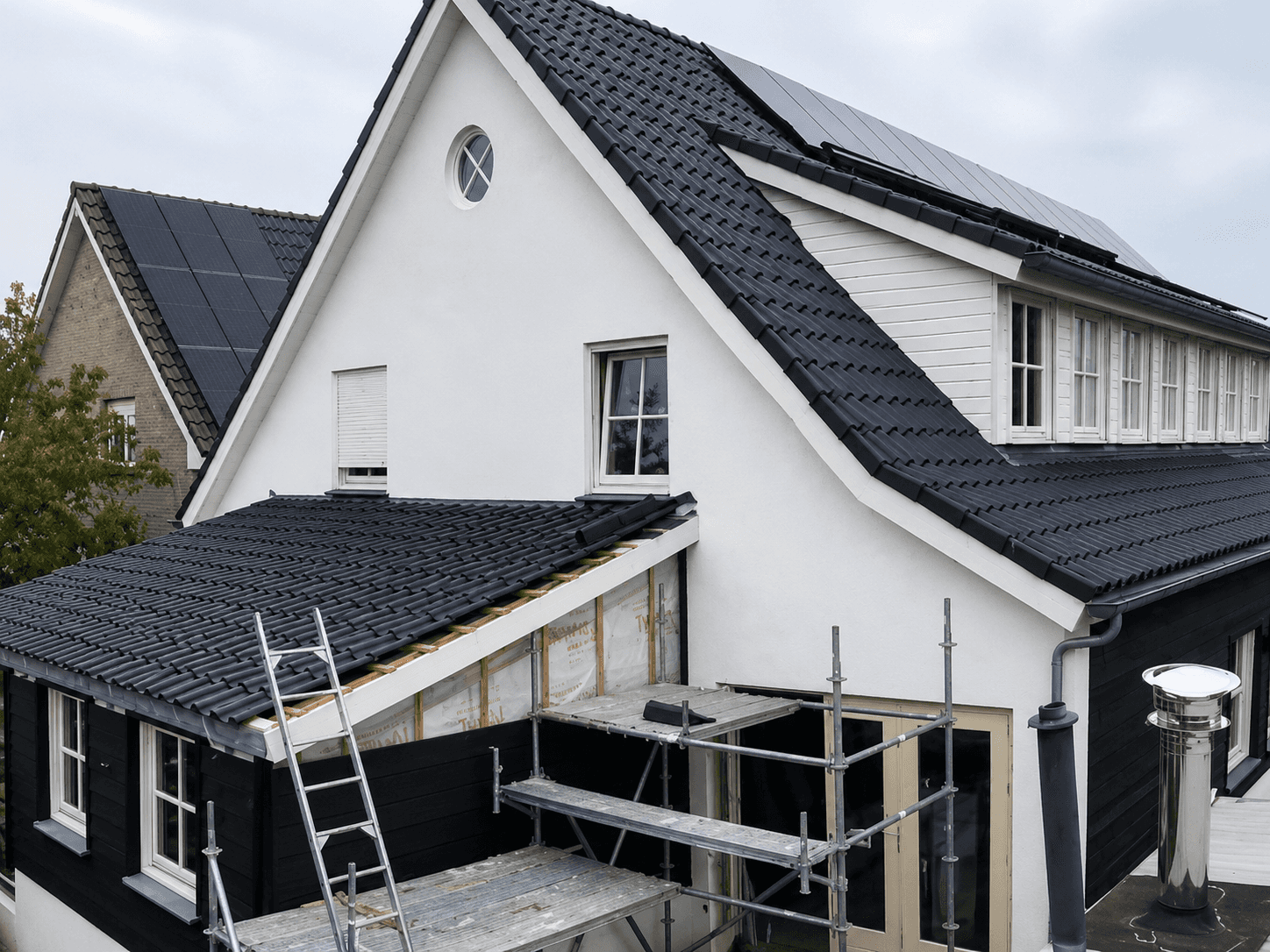 Woning met een nieuw pannendak en een aanbouw in uitvoering, uitgevoerd door Jubouw