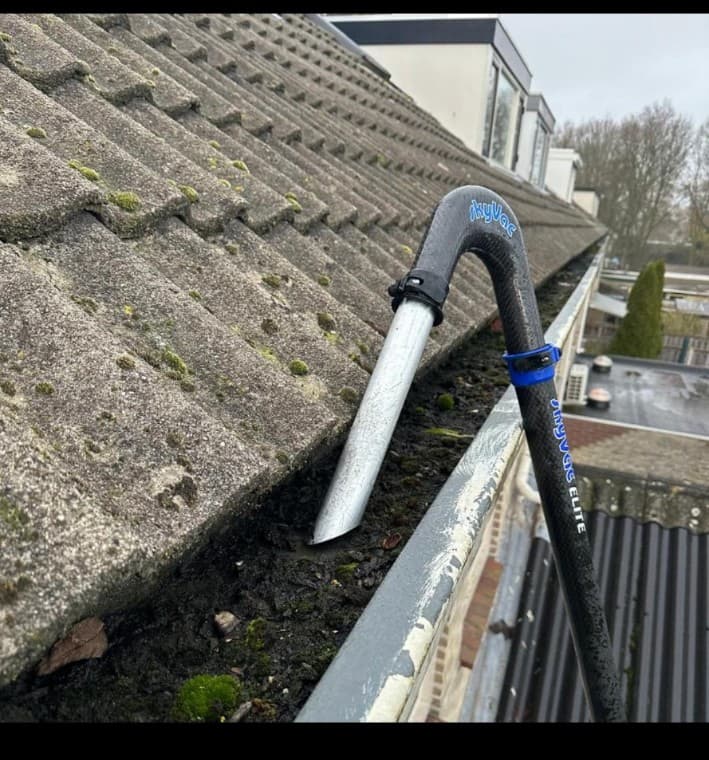 Dakgoot wordt gereinigd met de zuigarm van een SkyVac
